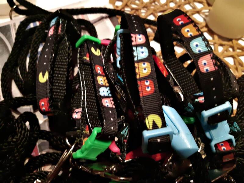Foto von den Welpenhalsbändern; schwarz mit farbigen „Pac-Man"